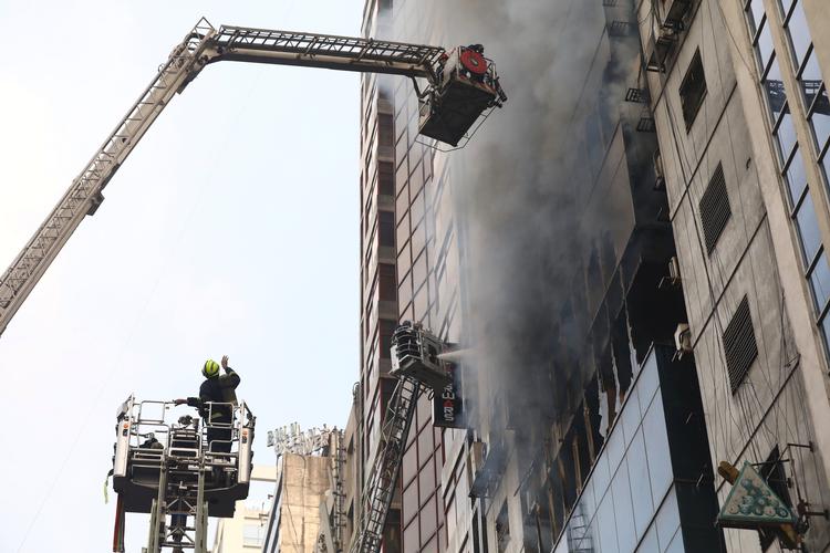 Ifølge avisen Daily Star har man set seks mennesker falde fra bygningen, tilsyneladende i et forsøg på at slippe væk fra flammerne. Foto: Mohammad Ponir Hossain/Ritzau Scanpix