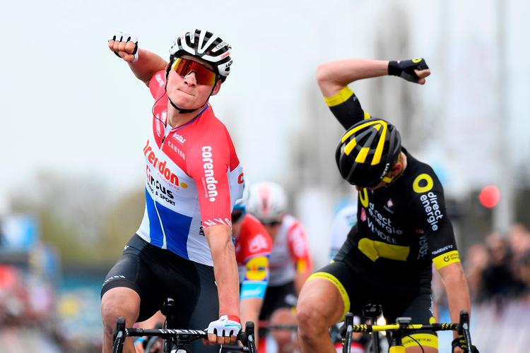 To talende armbevægelser i finalen på WorldTour-løbet Dwars door Vlaanderen - Mathieu van der Poel jubler over sejren, og Anthony Turgis ærgrer sig over at måtte nøjes med andenpladsen. Foto: Yorick Jansens/Ritzau Scanpix