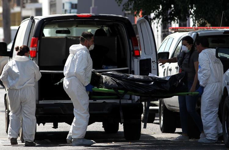 Retsmedicinere bærer liget af en af de dødsofre, der er blevet fundet i en af to massegrave i Mexico. Foto: Ulises Ruiz/Ritzau Scanpix