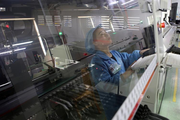 En fabriksansat arbejder på en elektronikfabrik i Jiaxing i Zhejiang-provinsen i Kina. Landets økonomi er aftaget de senere år, men vokser forsat. Foto: China Stringer Network/Ritzau Scanpix