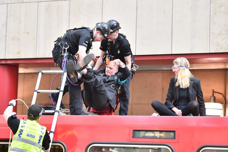 Politiet fjerner klimaaktivister, som limede sig selv fast til et tog på en station ved Canary Wharf. Foto: Daniel Leal-olivas/Ritzau Scanpix