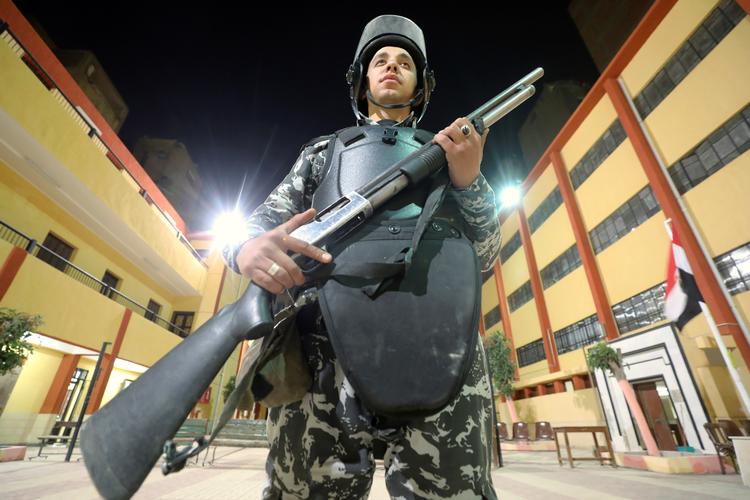 Politiet stod vagt om stemmeoptællingen i Egypten efter tre dages folkeafsteming om en ny forfatning, der både giver præsidenten længere tid i embedet og sikrer militærets position i landets magtstruktur. 
   Foto: Mohamed Abd El Ghany/Ritzau Scanpix