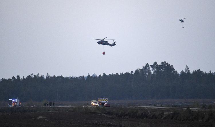 Helikoptere bistår slukningsarbejdet ved Hässleholm i Sverige. Branden startede tirsdag formiddag i en lade, og den spredte sig hurtigt. Foto: 50090 Johan Nilsson/tt/Ritzau Scanpix