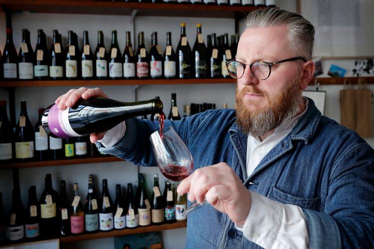 Solfinn Danielsen vil gerne væk fra, at vin er noget, man skal kloge sig på, mens man drikker: »Man behøver ikke at forstå vin eller kunne sætte ord på smagen for at kunne nyde den«, siger han, som her skænker et glas i sin forretning.
   Foto: Jens Dresling/POLFOTO
