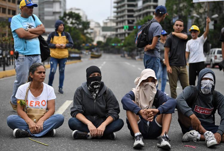 Unge venezuelanere viste deres utilfredshed med den siddende præsident Nicolas Maduro ved bl.a. at blokere veje i  Caracas i weekenden. Foto: Ronaldo Schemidt/Ritzau Scanpix