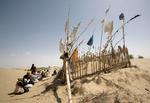 Den hellige gravplads Imam Asim menes at indeholde resterne af en hellig kriger fra det 8. århundrede. Her beder uighurerne om syndsforladelse og sætter som et symbol på deres bønner flag lavet af grene med små stykker stof.  Foto: Reinhard Krause/Ritzau Scanpix