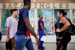 Lokale passerer butikker i et shopping område i Havana. Men der er ikke meget på hylderne. Landet er i dyb krise.  Foto: Alexandre Meneghini/Ritzau Scanpix