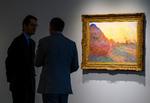 Medarbejdere fra Sotheby's står ved Monet-billedet 'Meules'. Det blev solgt for cirka 736 kroner.  Foto: Don Emmert/Ritzau Scanpix