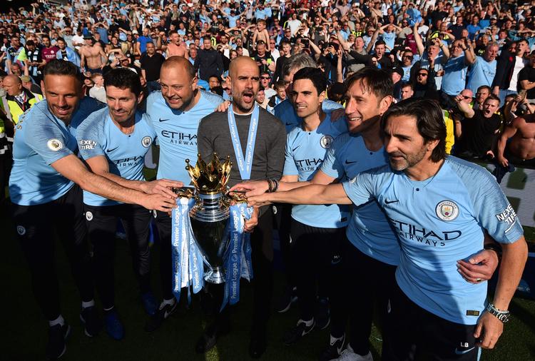 Manchester City-staben og klubbens manager Pep Guardiola, da det i søndags var lykkedes at forsvare Premier League-titlen.  Men måske trækker mørke skyer ind over succesholdet.
   Foto: Glyn Kirk/Ritzau Scanpix