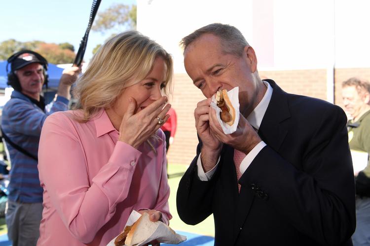 Den australske oppositionsleder Bill Shorten og hustruen Chloe spiser demokratipølse, efter de har afgivet deres stemme ved Australiens valg. Foto: Stringer/Ritzau Scanpix