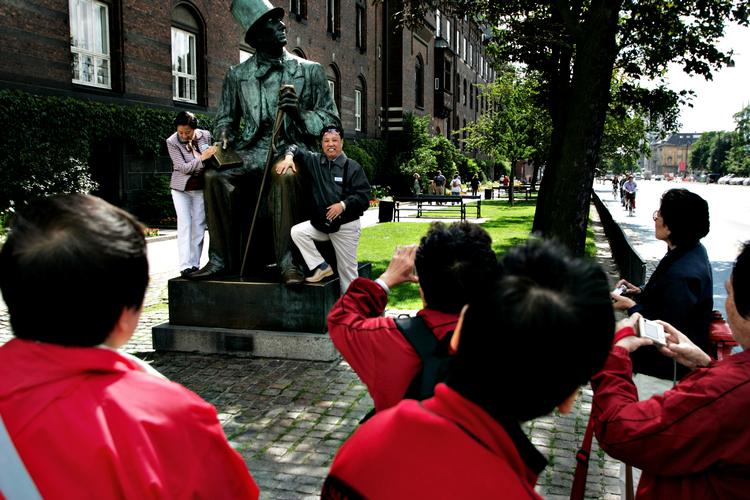 Kinesiske turister på Rådhuspladsen i København lader sig fotografere foran statuen af H.C. Andersen. Taxibranchen oplever et stigende problem med pirattaxikørsel 
   Foto: Thomas Borberg/POLFOTO