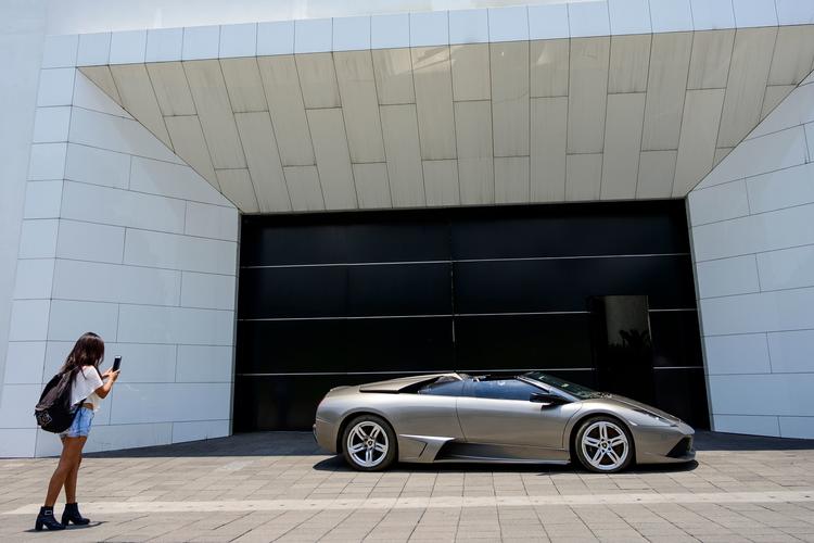 En kvinde tager et billede af den lamborghini, som skal på auktion i Mexico City. På søndag slår præsidentpaladset for første gang dørene op for den første af mange auktioner, der skal bortauktionere luksusvarer til fordel for fattige i landet. Foto: Pedro Pardo/Ritzau Scanpix