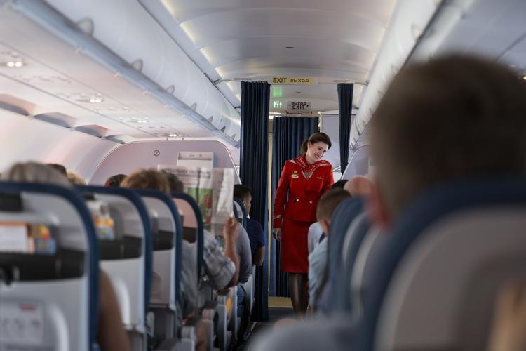 En stewardesse tilser passagererne. Dem er der blevet lidt færre af på indenrigsflyvninger i Sverige, men ifølge Transportstyrelsen er det for tidligt at sige, om den svenske flyafgift er skyld i faldet. Foto: Finn Frandsen/POLFOTO