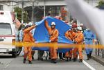 Redningsarbejdere på stedet, hvor mange mennesker blev angrebet af en mand med kniv. Angrebet fandt sted tirsdag morgen lokal tid i Kawasaki, syd for Tokyo.  Foto: Kyodo/Ritzau Scanpix