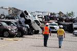 Arbejdere passerer ødelagte trucks hos i Toyota forhandler i byen Jefferson City i  Missouri. Tornadoerne har bragt megen ødelæggelse med sig.   Foto: Carlo Allegri/Ritzau Scanpix
