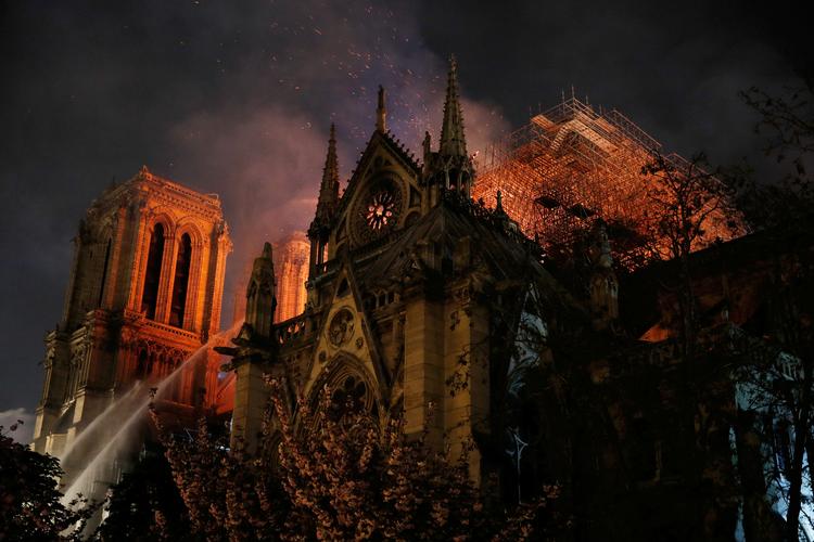 Da flammerne stod op ad Notre-Dame-katedralens mure, flere timer efter at spiret var faldet sammen, var der enighed om, at Notre-Dame skal genopbygges. Men siden da er enigheden sluppet op.
   Foto: Philippe Wojazer/Ritzau Scanpix