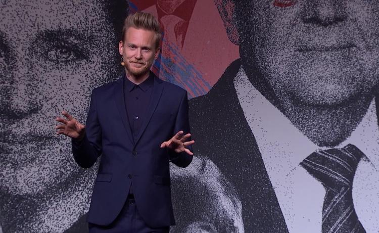 Med højt hår og i skarpt mørkt  jakkesæt har Huxi Bach ladet satirens ragekniv lyne i programmet 'Huxi Bach: Valget plus det løse'. Foto: DR