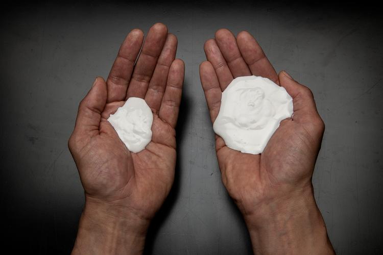  I højre hånd er 40 gram solcreme. Det er den mængde solcreme, voksne anbefales at bruge af myndighederne. I venstre hånd er der 12 gram solcreme. Det er en typisk håndfuld, som folk hældte op, når de blev bedt om at tage ’en håndfuld’ på. 
 Foto: Peter Hove Olesen/POLFOTO