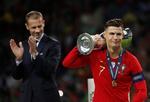 Uefas' præsident Aleksander Ceferin  klapper, mens Cristiano Ronaldo slæber af sted med endnu en pokal. Foto: Carl Recine/Ritzau Scanpix