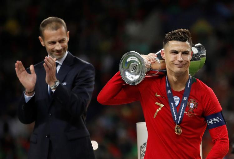Uefas' præsident Aleksander Ceferin  klapper, mens Cristiano Ronaldo slæber af sted med endnu en pokal. Foto: Carl Recine/Ritzau Scanpix