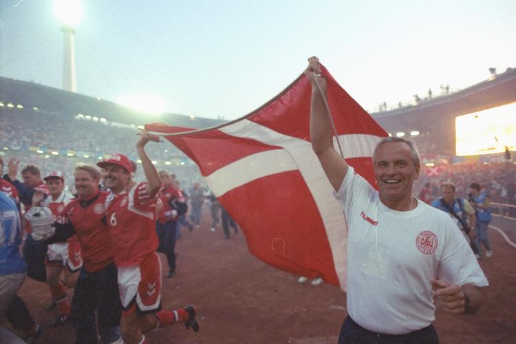 Richard Møller Nielsen, til højre, løfter Dannebrog efter sejren til EM-finalen i 1992, som Danmark vandt 2-0 over Tyskland.

Den fy'ynske landstræner var i begyndelsen stærkt udskældt for sin defensive taktik og kontroverser med flere stjernespillere. Da den daværende formand for divisionsforeningen deltog i hylekoret, svarede Richard Møller Nielsen køligt igen:

»Et godt, solidt fynsk bøgetræ taber ikke et eneste blad, blot fordi et svin gnubber sig op ad det«.

Efter EM-sejren forstummede meget af kritikken mod Richard Møller Nielsen, som fortsatte på posten frem til 1996.

I alt 46 kampe. Pointsnit: 1,74. Foto: Kim Agersten/POLFOTO