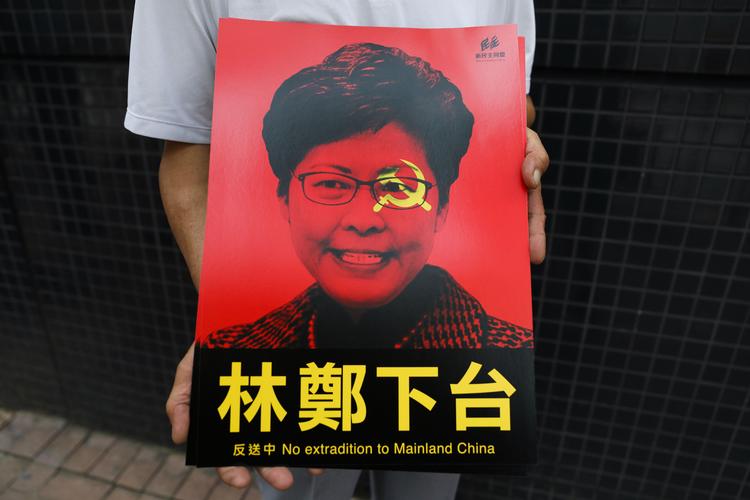 En demonstrant fremviser en plakat med Carrie Lams kontrafej, som tydeligt symboliserer, hvad mange borgere i Hongkong mener: At hun er i lommen på den kinesiske regering. 
   Foto: Dale de la Rey/Ritzau Scanpix