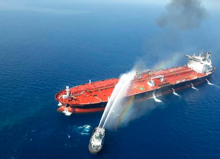 Det norske tankskib 'Front Altair' brød i brand efter angrebet torsdag. På billedet er et iransk flådefartøj ved at bekæmpe ilden.
   Foto: -/Ritzau Scanpix