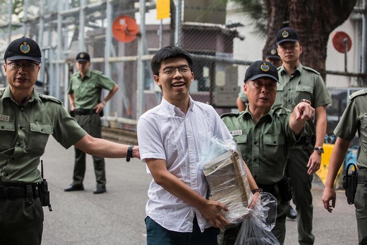 Hongkongs mest kendte demokratiforkæmper, Joshua Wong, forlader fængslet, efter at han mandag formiddag pludselig blev løsladt af myndighederne - angiveligt i et forsøg på at dæmpe den folkelige vrede, som er opstået mod regeringen. Foto: Isaac Lawrence/Ritzau Scanpix