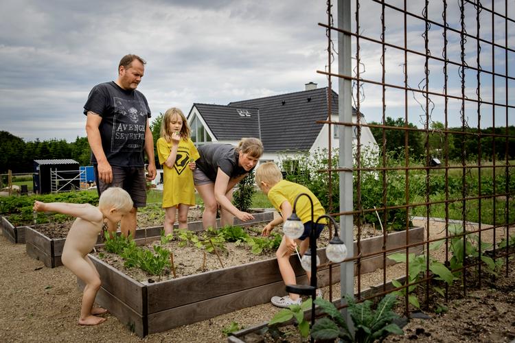 Køkkenhaven er ved at tage form ved familien Johannesens nybyggede, energivenlige hus. Katrine og Jesper synes, at det er tilfredsstillende at være så selvforsynende som muligt, og børnene Julie, Johan og lille Topper smager gerne på varerne.   Foto: Mads Nissen/POLFOTO