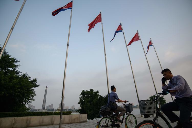 Kinas og Nordkoreas flag vejer side om side på Kim Il Sung Plads i Pyongyang. Kinas præsident, Xi Jinping, ankom i dag til landet for at mødes med Kim Jong-un. Besøget er det første fra en kiinesisk leder besøger landet i 14 år.  Foto: Ed Jones/Ritzau Scanpix