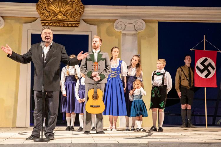 Selv om kaptajn von Trapp (Morten Hemmingsen) til at begynde med ikke vil være med, ender det i triumf for den musikalske familie med de mange børn. Tommy Kenter er sjov - og måske en smule for meget. Foto: Esben Salling