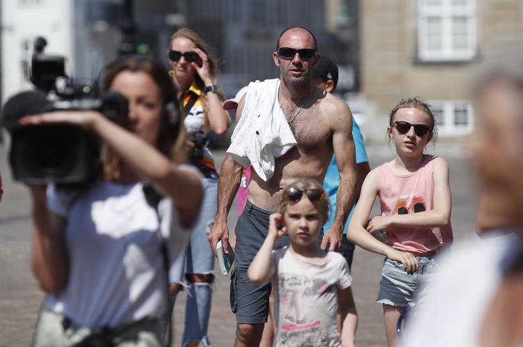 Hedebølgen har ramt København. Selvblandt dem, der venter på Mette Frederiksen på Amalienborg Slotsplads, er der folk i bar overkrop. Foto: Jens Dresling/POLFOTO