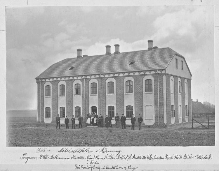 Personale og elever foran den nybyggede missionsskole bag Herning Kirke. Provst Koch er nr. 3 fra højre. Missionærelev Gøtzsche, der hjalp med tegningerne, er ikke med, da han allerede var udsendt til Indien. Foto: Danmission Photo Archive. 