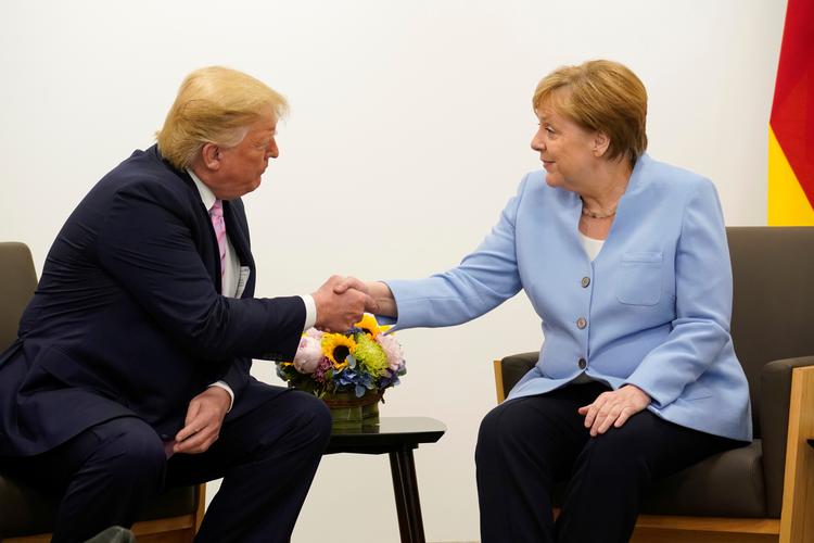 Donald Trump og Angela Merkel udvekslede pæne ord efter ankomsten til Japan. Foto: Kevin Lamarque/Ritzau Scanpix