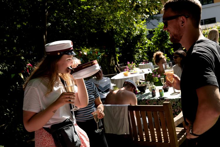 Thea Henriksen er til gilde hos en klassekammerat. Hun bider i en hue, hvilket betyder held og lykke til studenten.    Foto: Peter Hove Olesen/POLFOTO