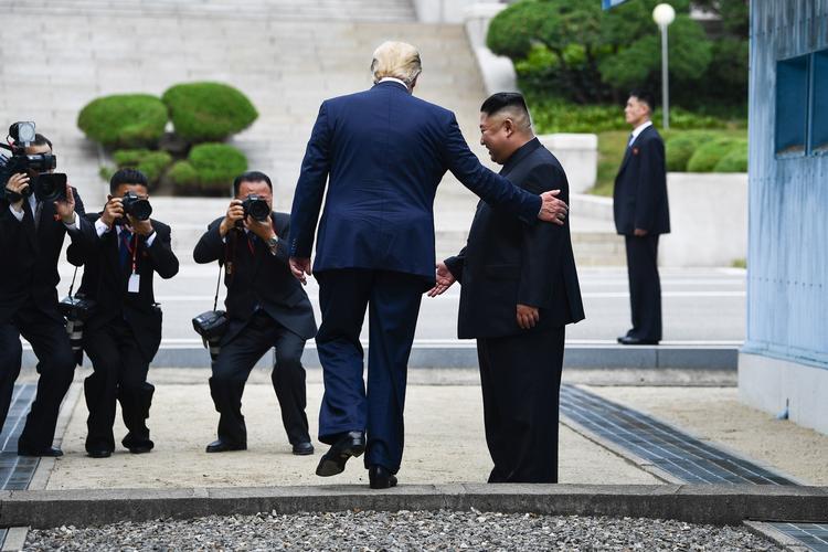 Donald Trump får en hånd, da han træder ind i Nordkorea. Kort efter gik Kim Jong-un med ham ind i Sydkorea. Foto: Brendan Smialowski/Ritzau Scanpix