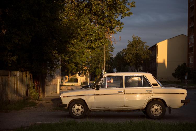 En russisk Lada i solnedgang i boligområdet Novoye Stroenie, Daugavpils, Letland.  Omkring 80 procent af indbyggerne er russisktalende, og i mange af disse hjem er det russisk TV, der kommer gennem parabolen.  Foto: Katinka Hustad/POLFOTO