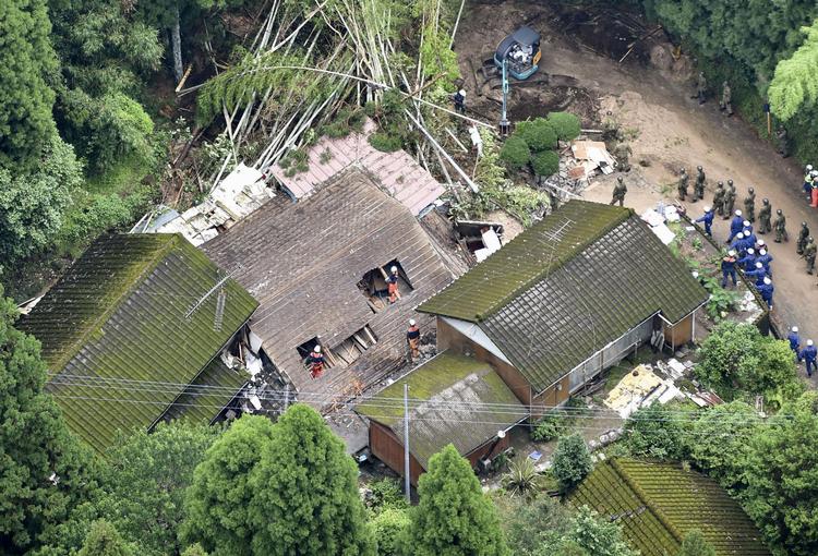 Redningsarbejdere leder efter overlevende, efter at et hus er kollapset i et jordskred som følge af heftigt nedbør i  Soo, Kagoshima i det sydvestlige Japan.  Foto: Kyodo/Ritzau Scanpix