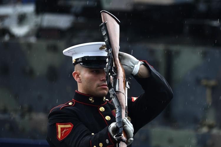 Et medlem af USA's militære orkester optræder i regnen. De kaster og griber deres geværer. 
 Foto: Brendan Smialowski/Ritzau Scanpix