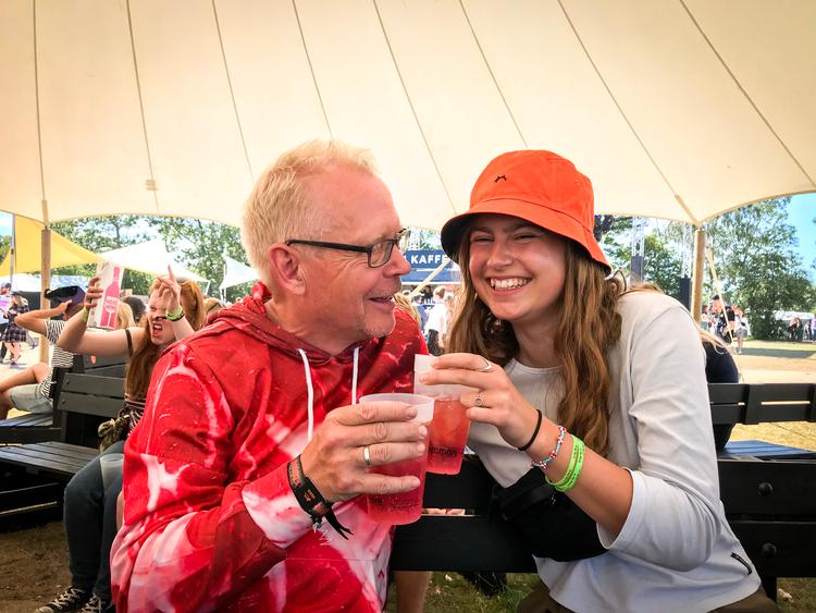Petrea Dalum nyder en cocktail med sin midlertidige Roskilde-far. I baggrunden har nogen en fest.  