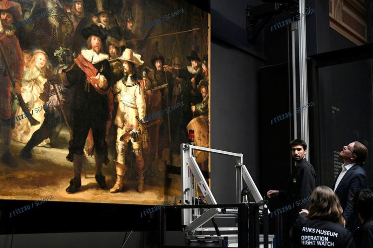 Iklædt t-shirts på påskriften 'Operation Night Watch' er de hollandske konservatorer nu gået i gang med restaureringen. Ritzau/Scanpix PIROSCHKA VAN DE WOUW 