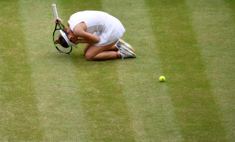 Simona Halep knækkede sammen og faldt på knæ, da det sidste slag i Wimbledon-finalen mod Serena Williams var slået, og hun havde vundet.
   Foto: Toby Melville/Ritzau Scanpix