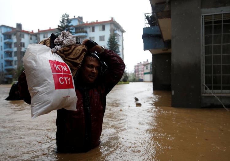 De lokale forsøger at slæbe deres ejendele til tørre steder i hovedstaden. Foto: Navesh Chitrakar/Ritzau Scanpix