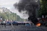 Optøjerne udspiller sig få timer efter, at præsident Emmanuel Macron i selskab med andre europæiske ledere har fejret den franske nationaldag. Foto: Kenzo Tribouillard/Ritzau Scanpix