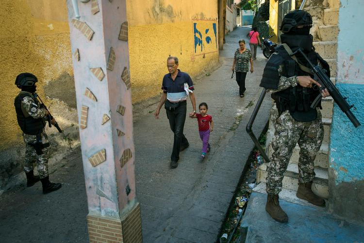 Maskerede betjente fra en eliteafdeling i politiet patruljerer i et slumkvarter i Caracas. Venezuela kritiseres for brud på menneskerettighederne.  
 Foto: Rodrigo Abd/Ritzau Scanpix