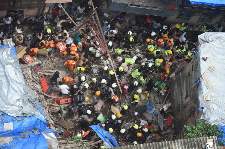 Redningsmandskab leder efter overlevende i murbrokkerne af den fire etager høje bygning, der er kollapset i Mumbai. Det er uklart, hvor mange mennesker der er fanget i bygningen.  Foto: Punit Paranjpe/Ritzau Scanpix