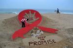 Den indiske sandskulpturkunstner, Sudersan Pattnaik, arbejder på en sandskulptur i anledning af aids dagen. Sidste år var der 33 pct. færre tilfælde af hiv-relaterede dødsfald sammenlignet med 2010.  Foto: Asit Kumar/Ritzau Scanpix