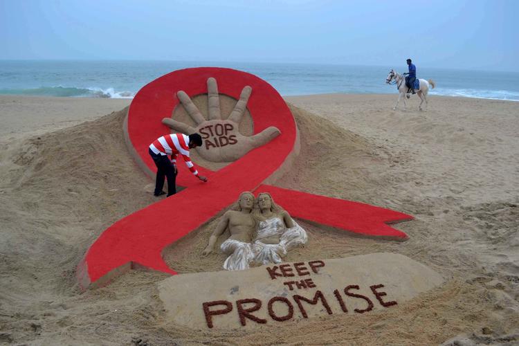Den indiske sandskulpturkunstner, Sudersan Pattnaik, arbejder på en sandskulptur i anledning af aids dagen. Sidste år var der 33 pct. færre tilfælde af hiv-relaterede dødsfald sammenlignet med 2010.  Foto: Asit Kumar/Ritzau Scanpix