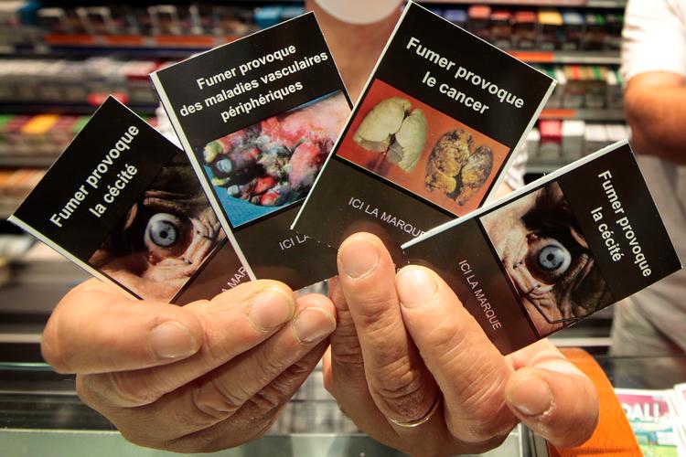Siden 2011 har tobakspakker skullet bære billeder, der advarede mod effekten af rygning. Det kan som her være blindhed, kræft eller vævsskader fra dårligt blodomløb.  Foto: Eric Gaillard/Scanpix Denmark