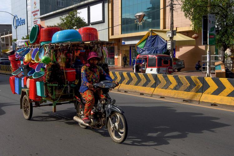 En kvinde fra Cambodja fragter sine varer i hovedstaden Phnom Penh. Nu har en multiresistent malaria spredt sig i landet og til flere andre lande, lyder advarslen.  Foto: Tang Chhin Sothy/Ritzau Scanpix